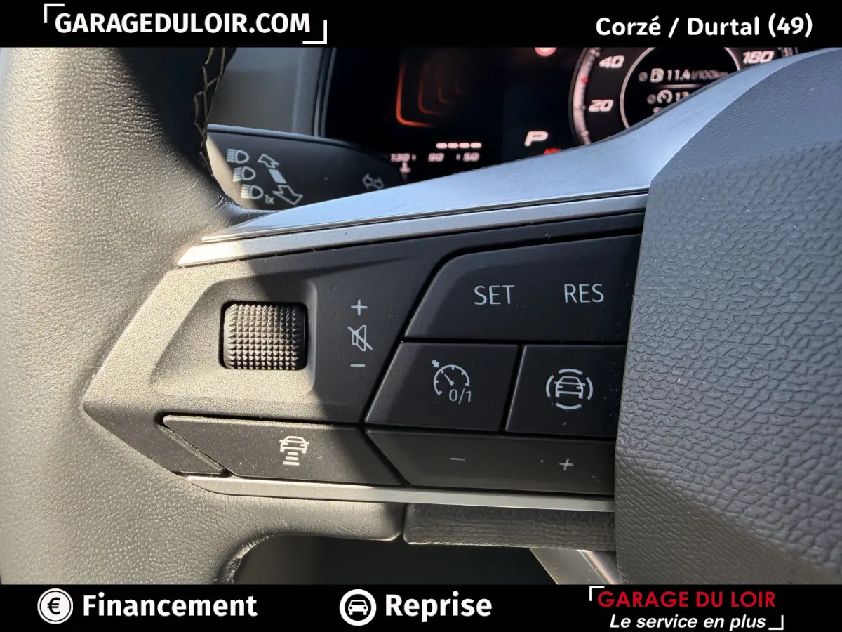 Gros plan sur les commandes multifonctions noires du volant du SEAT Arona 2025, avec affichage digital en arrière-plan.