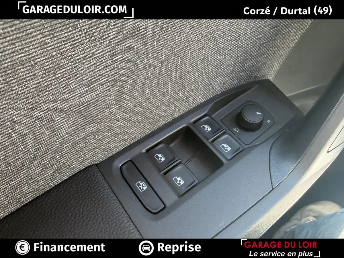 Gros plan sur les commandes des vitres électriques et rétroviseurs côté conducteur d'un SEAT Arona noir, intérieur tissu gris.
