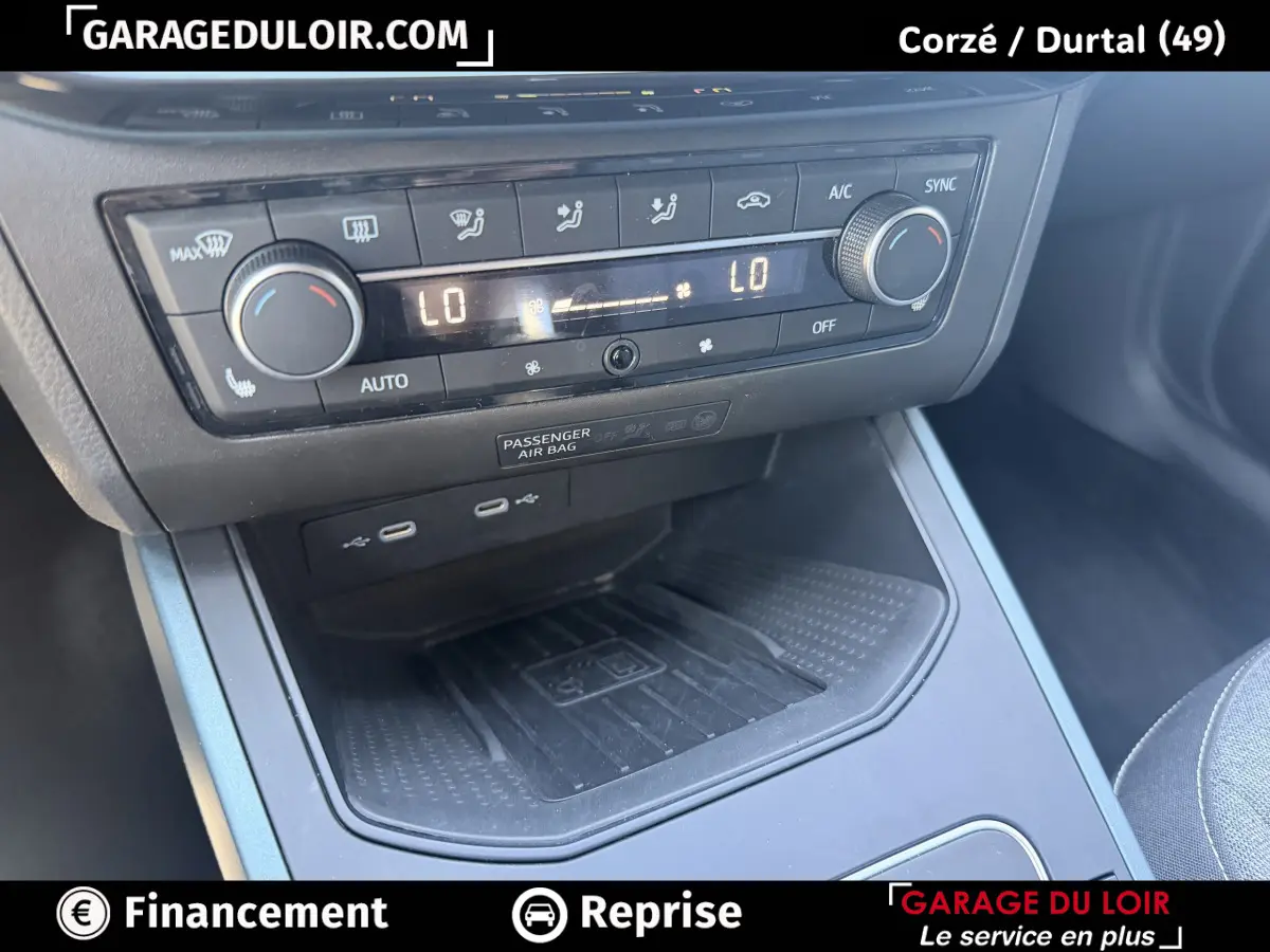 Gros plan sur la console centrale du SEAT Arona 2025 noire, avec commandes climatisation et ports USB visibles.