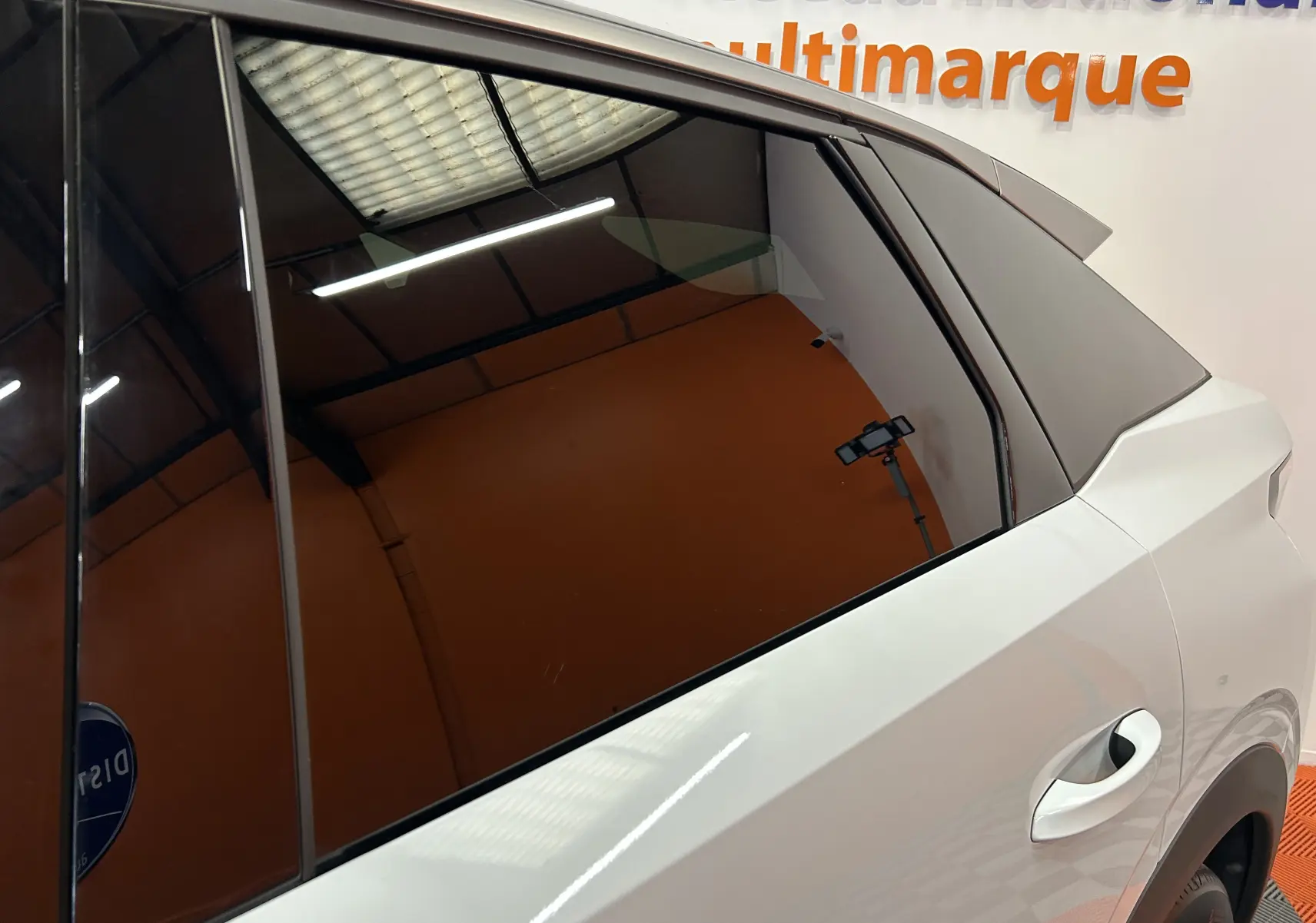 Vue rapprochée du côté gauche arrière du Peugeot 3008 blanc Okenite, mettant en valeur la porte et la vitre teintée.