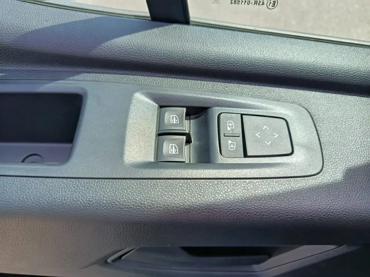 Commandes des vitres électriques et réglage des rétroviseurs sur la porte intérieure côté conducteur du Renault Master blanc.
