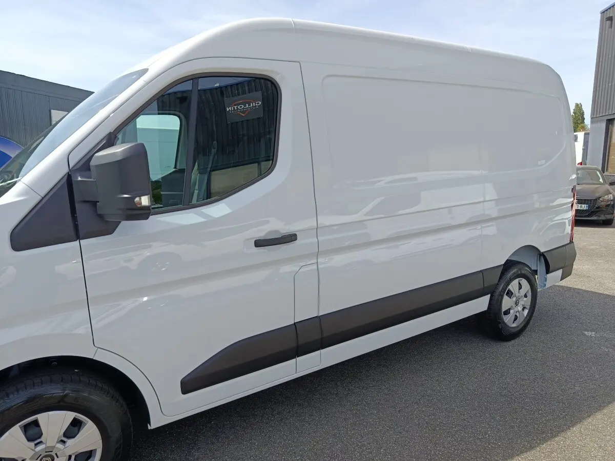 Vue de profil côté gauche du Renault Master blanc, fourgon utilitaire avec porte latérale pleine et rétroviseur noir.