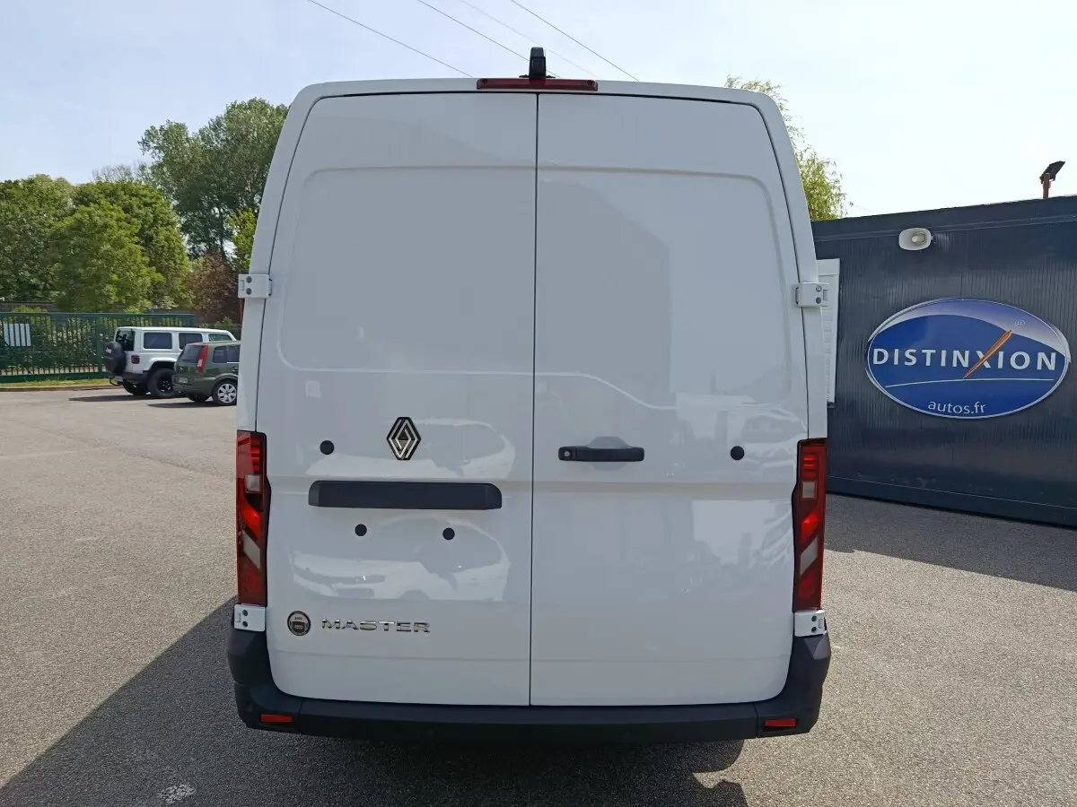Vue arrière d’un utilitaire Renault Master blanc avec portes battantes et feux rouges verticaux.