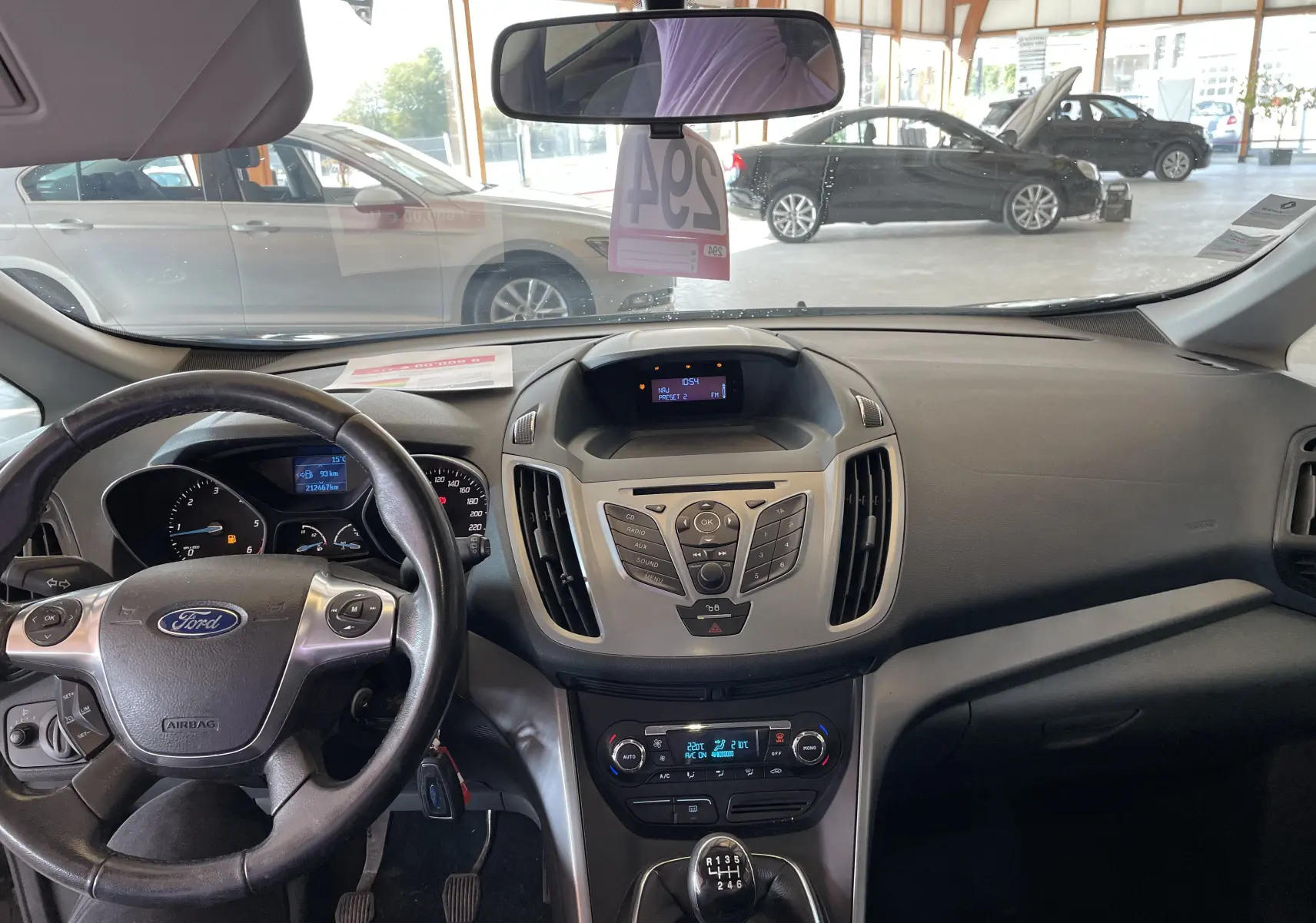 Vue intérieure du tableau de bord et volant noir de la Ford C-MAX gris 2012 avec boîte manuelle, en lumière naturelle.