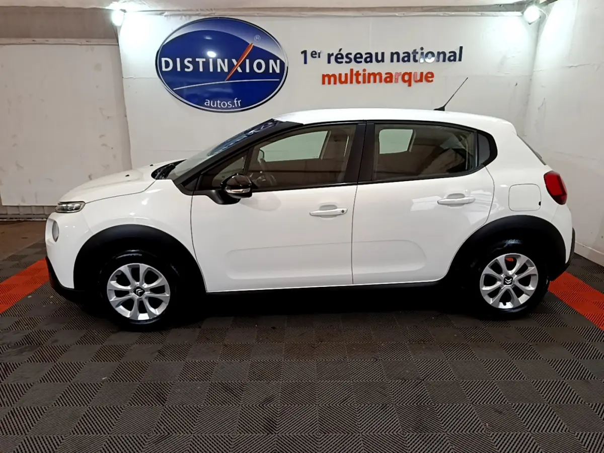 Profil côté gauche d'une Citroën C3 blanche PureTech 68 BVM Feel, avec jantes argentées et protections noires.