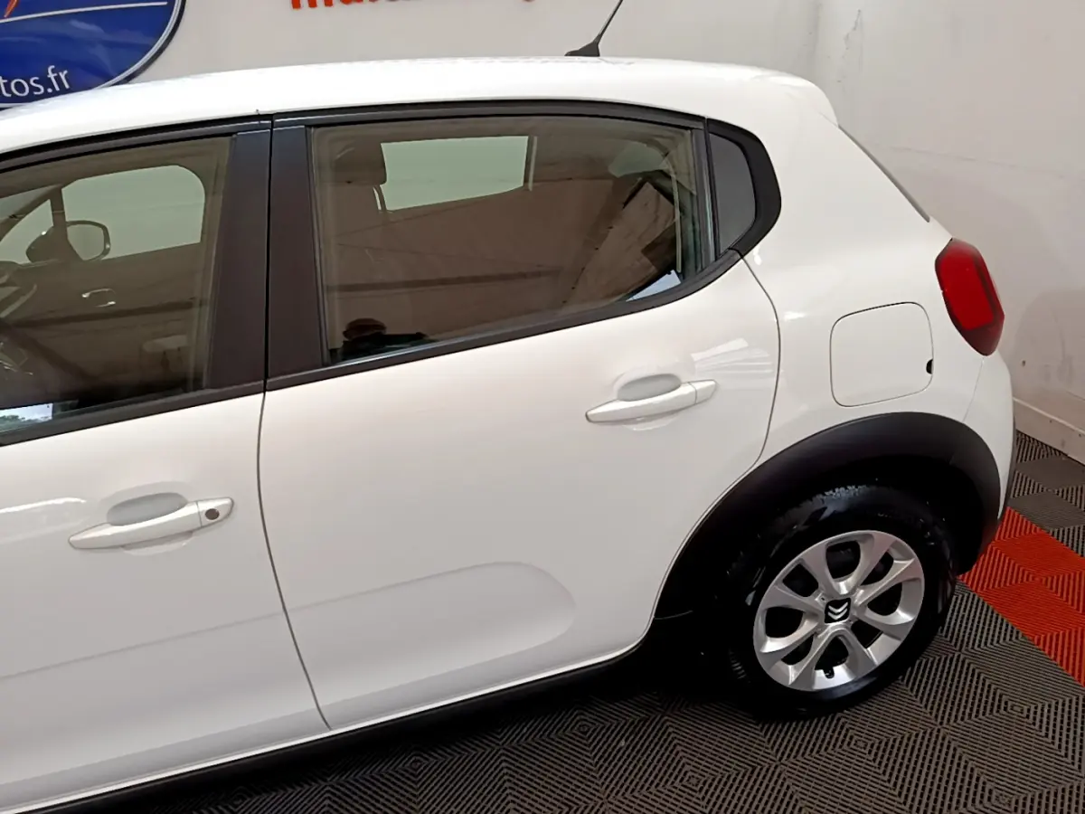 Vue latérale droite d'une Citroën C3 blanche de 2018, mettant en valeur la porte arrière et la roue arrière avec jante alu.