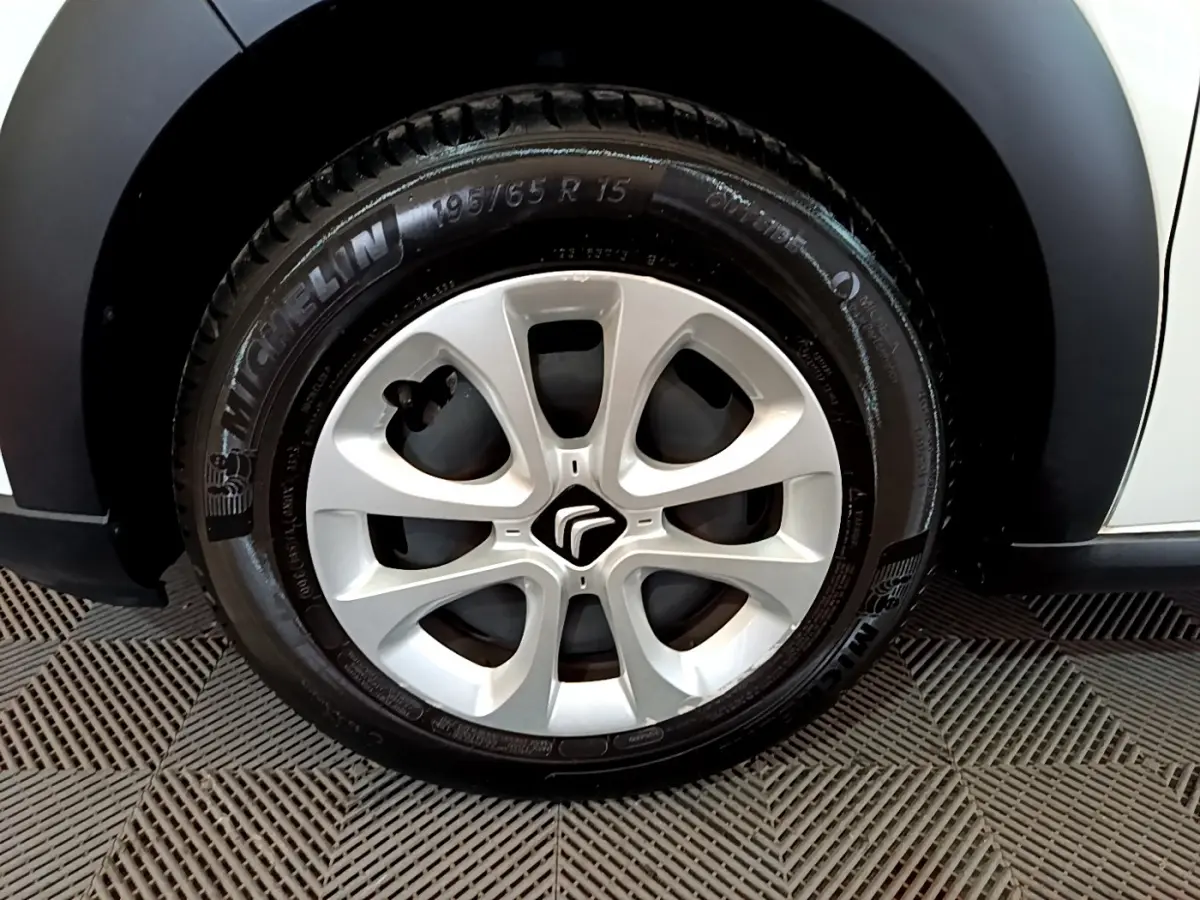 Gros plan sur la roue avant gauche d'une Citroën C3 blanche de 2018 avec jante en alliage et pneu Michelin.