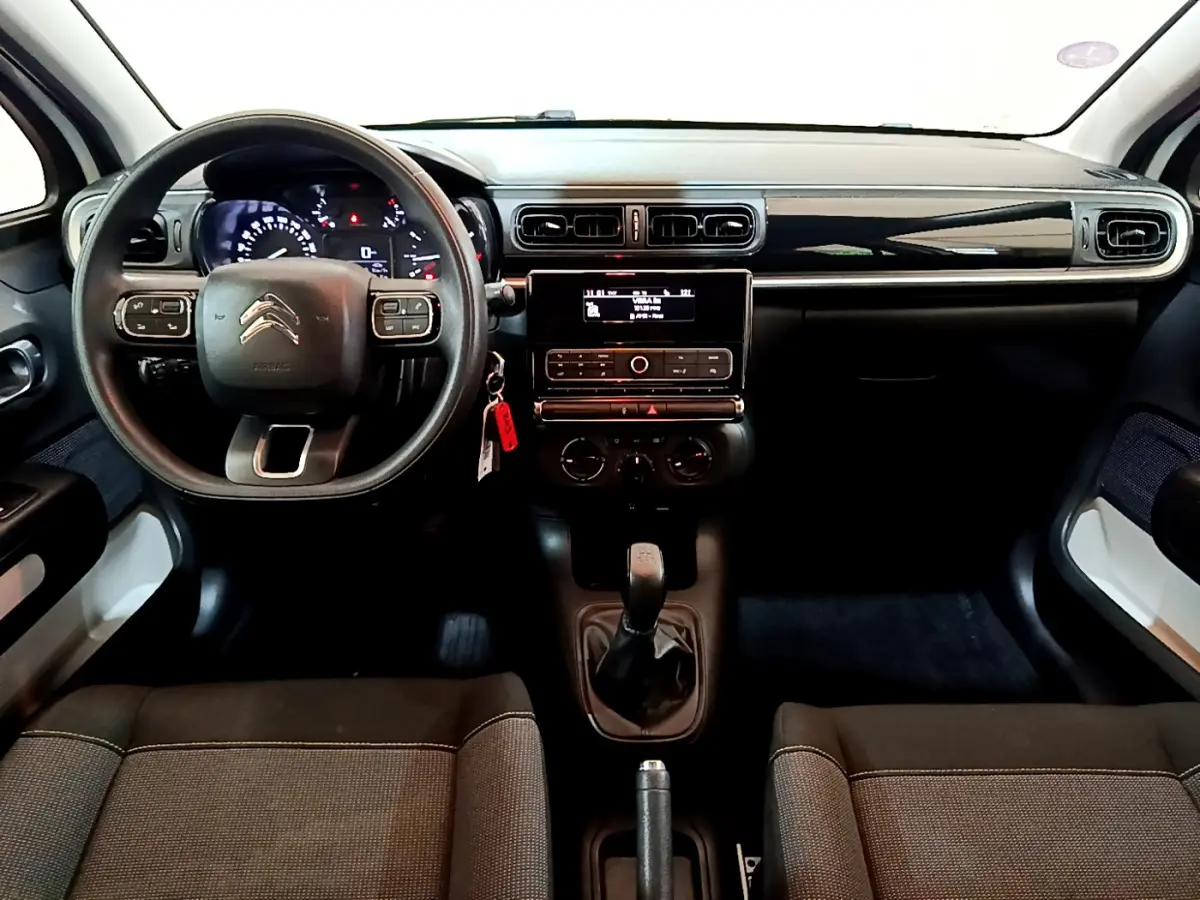 Tableau de bord et intérieur noir de la Citroën C3 PureTech 68 BVM Feel 2018 vus de face, volant multifonctions et levier manuel.