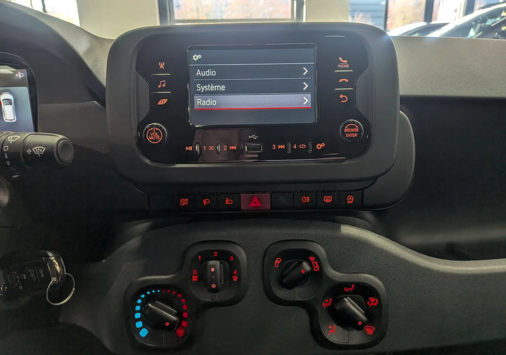 Tableau de bord de la Fiat Panda 2025 avec écran tactile central et commandes de climatisation en vue frontale rapprochée.