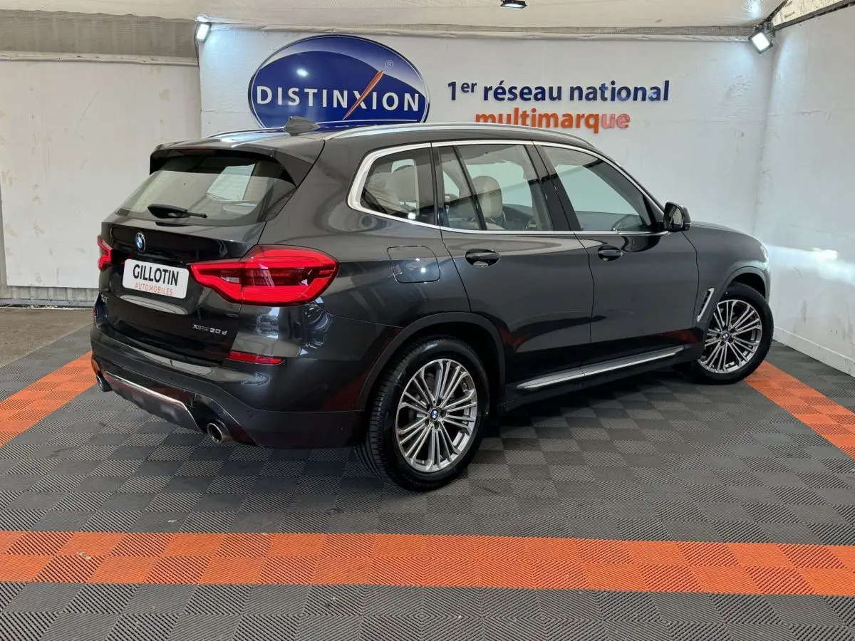 BMW X3 xDrive30d gris foncé vu en 3/4 arrière droit, avec jantes alliage et feux arrière LED visibles.