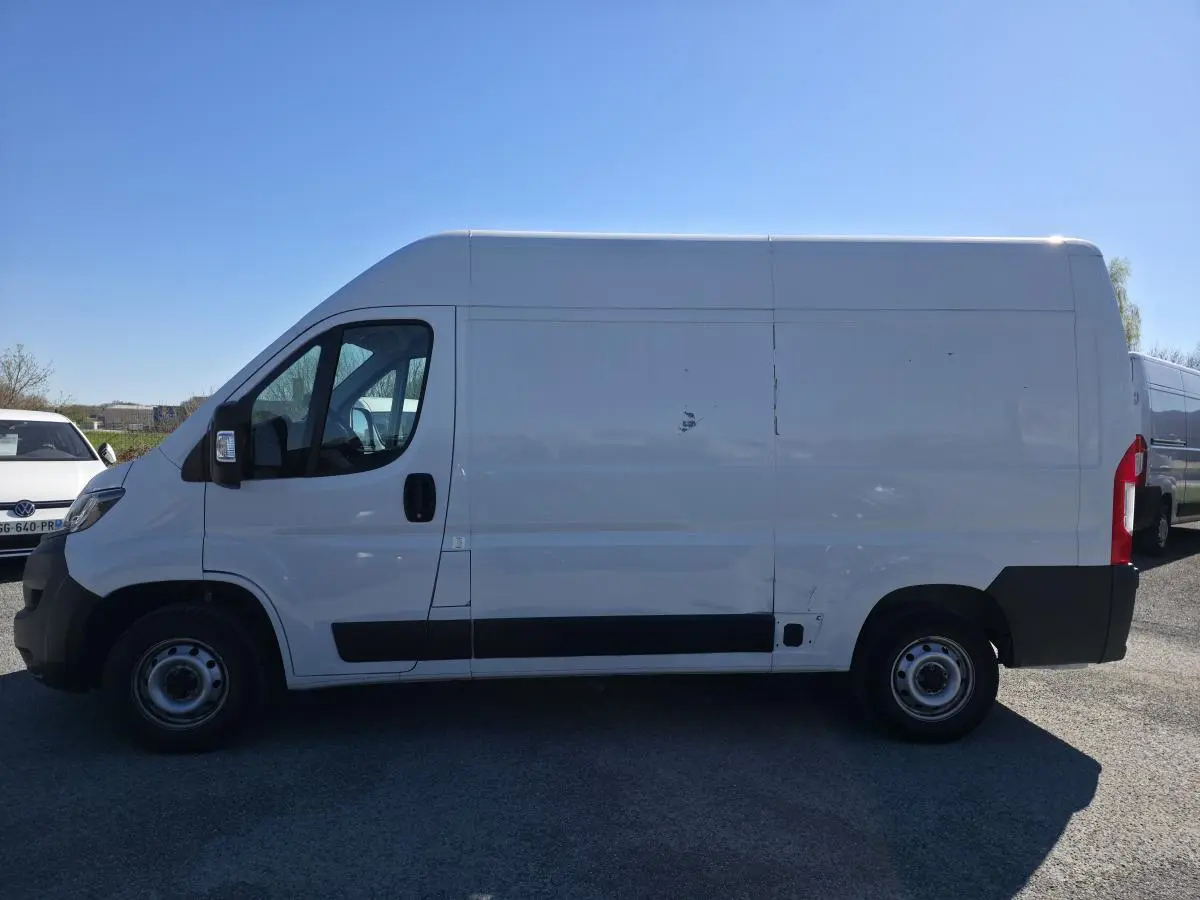 Fiat Ducato Fourgon blanc en vue de profil côté gauche, fourgon tôlé avec porte latérale coulissante.