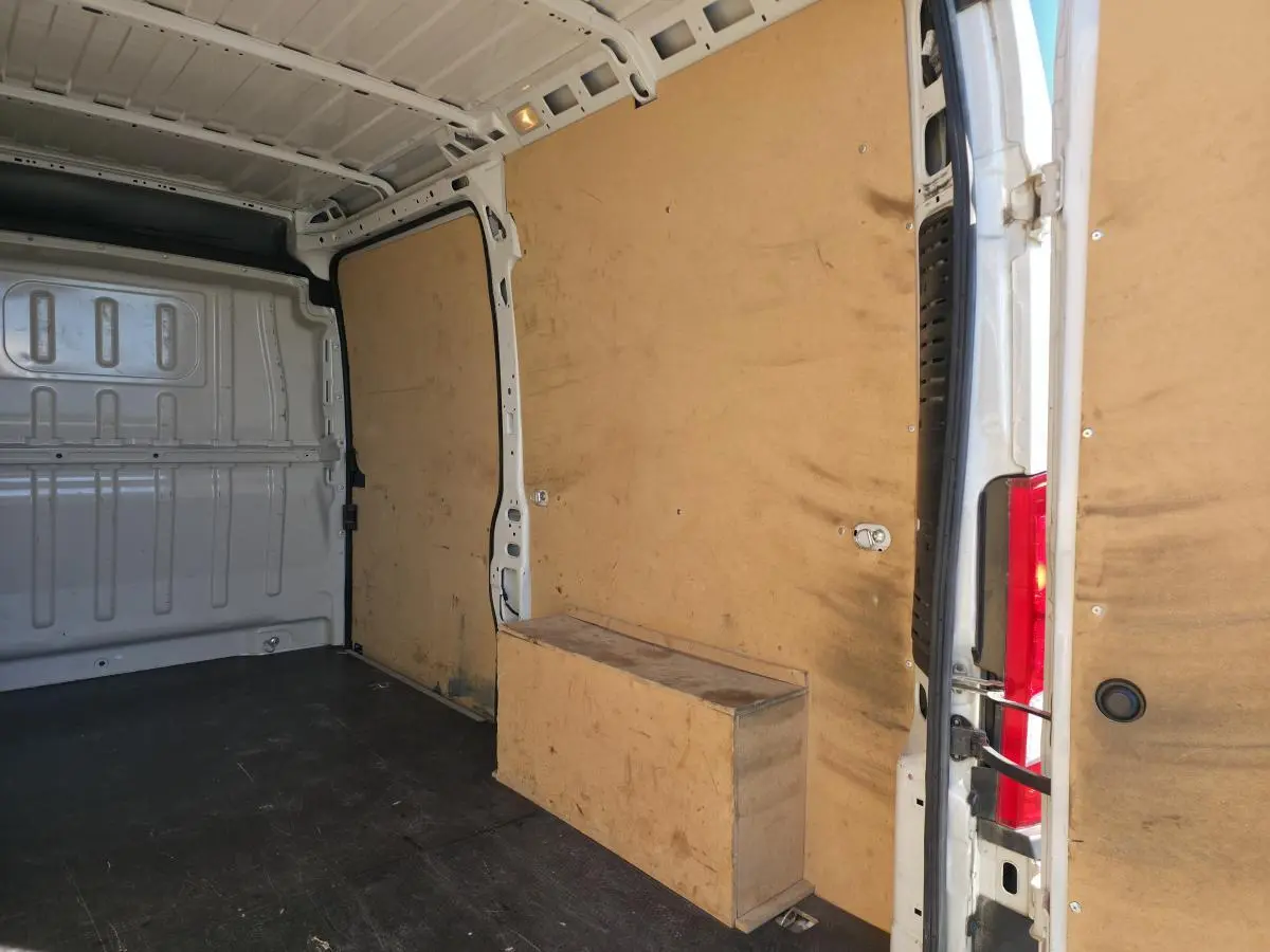 Vue intérieure arrière droite du fourgon FIAT Ducato blanc, montrant l'espace de chargement avec parois en bois.