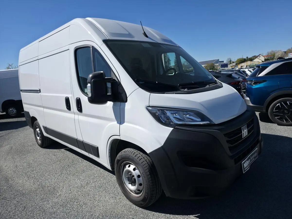 Fiat Ducato Fourgon blanc en 3/4 avant droit, avec calandre noire et jantes acier 16 pouces visibles.