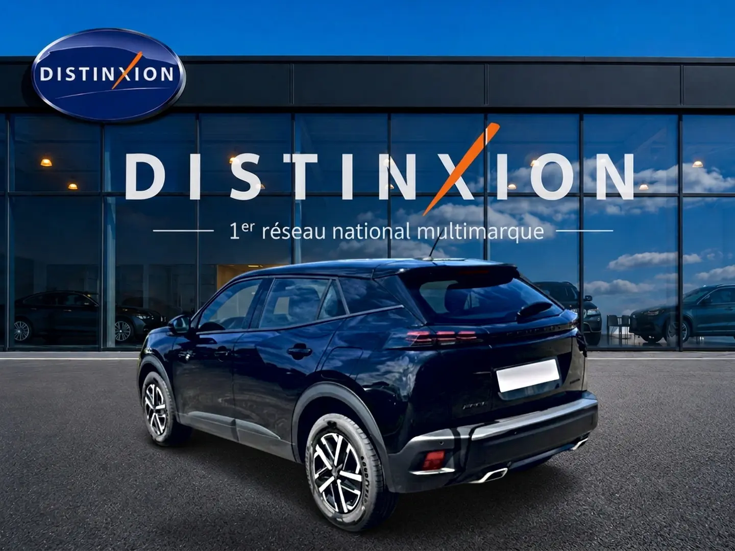 Peugeot 2008 noir en 3/4 arrière droit, avec becquet et feux arrière LED, devant une vitrine Distinxion.