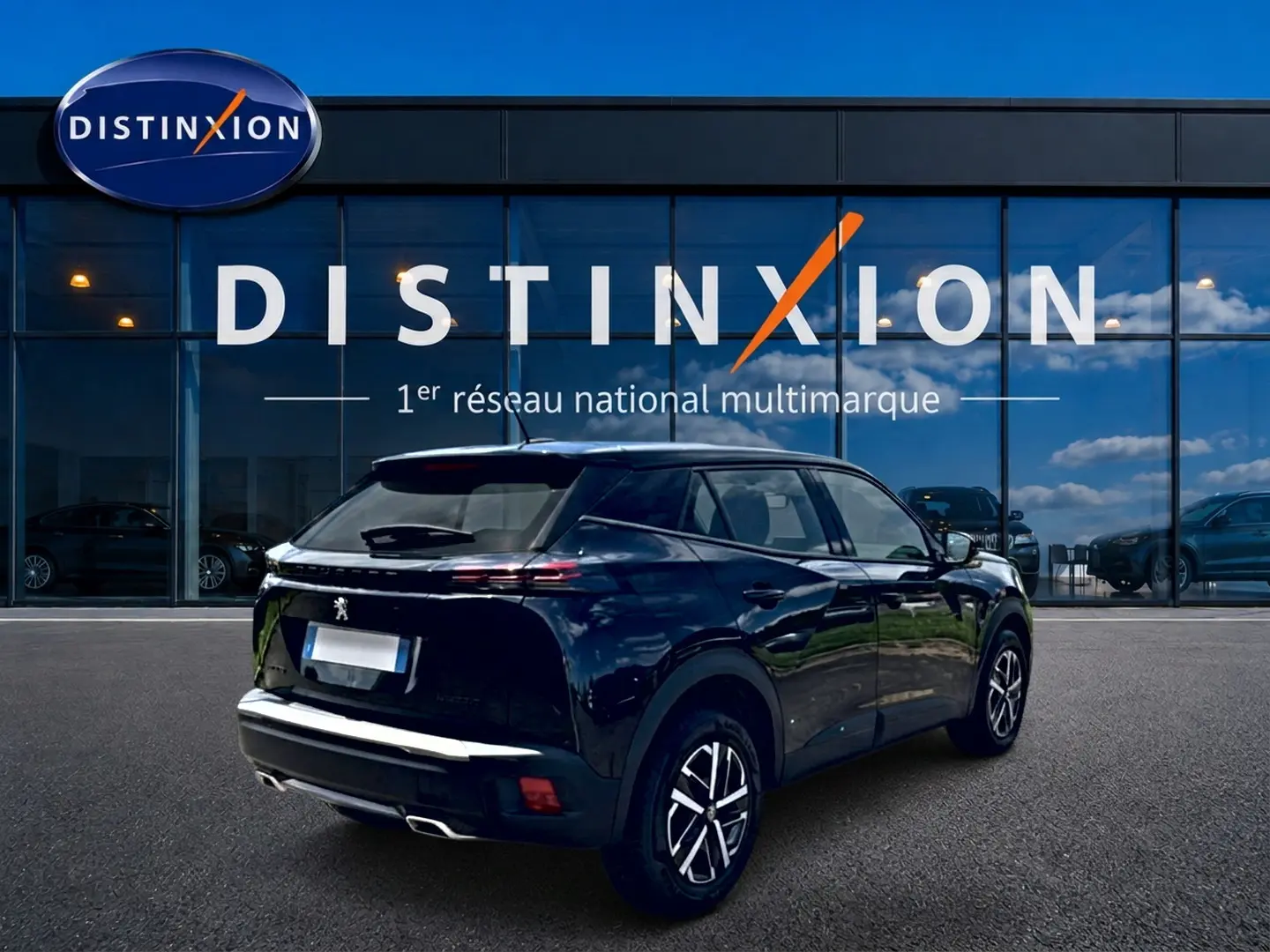 Vue 3/4 arrière droite d'un Peugeot 2008 noir 2025 avec feux arrière LED et becquet arrière visible.