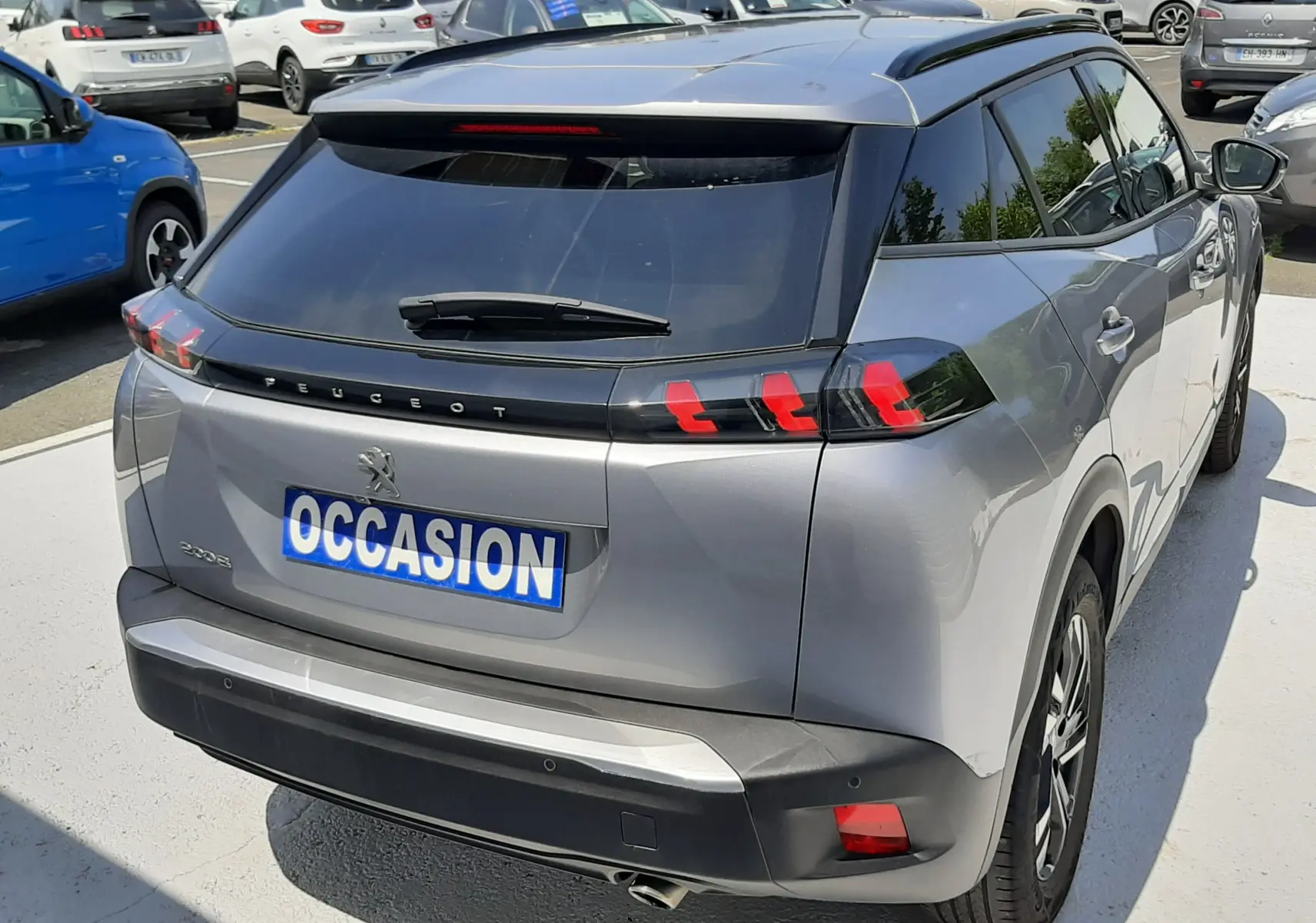 Vue 3/4 arrière droite d'un Peugeot 2008 gris Artense avec feux arrière à griffes rouges et toit noir brillant.