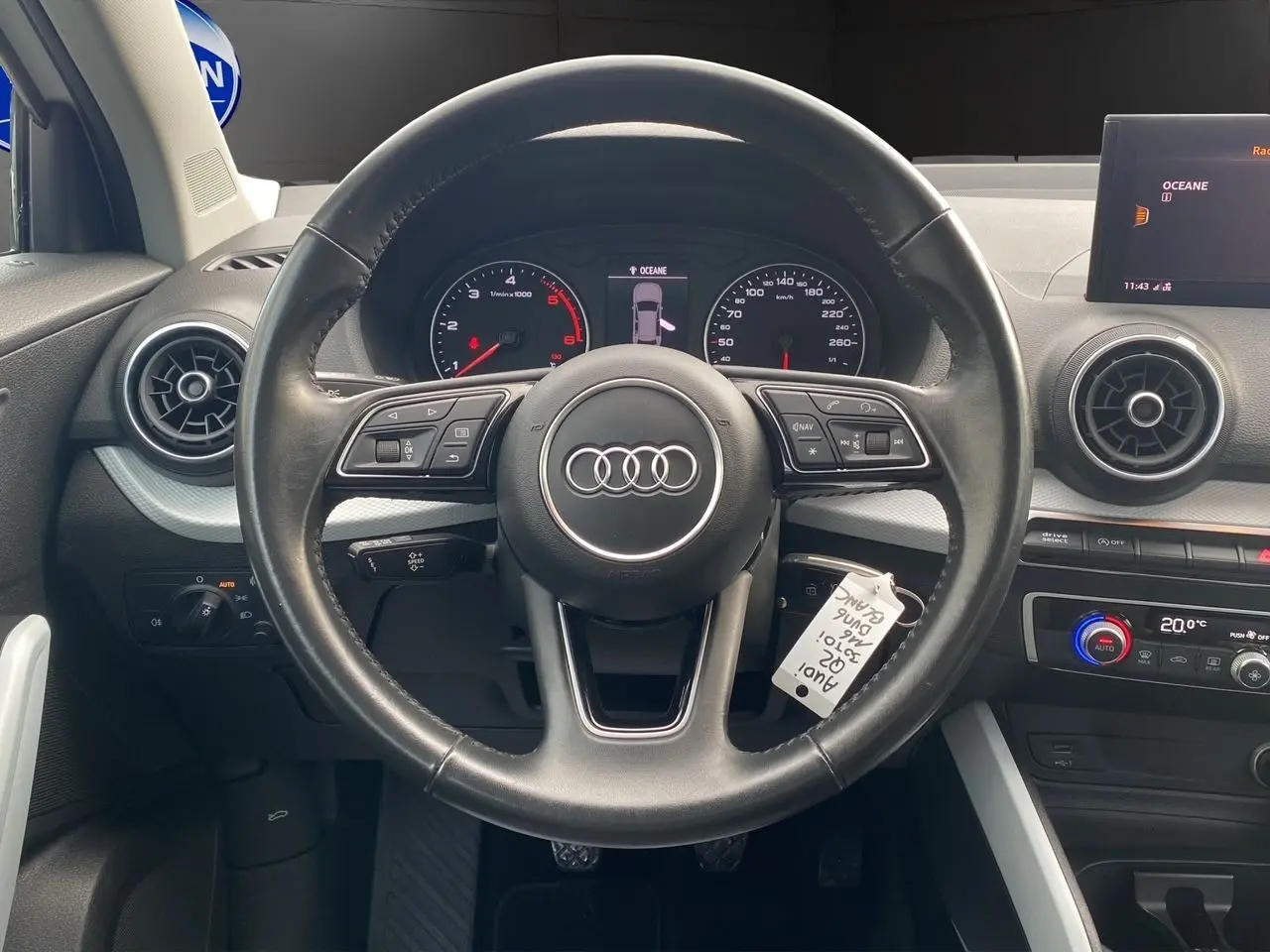 Vue intérieure centrée sur le volant noir de l'Audi Q2 30 TDI 2019 avec tableau de bord et écran multimédia visible.