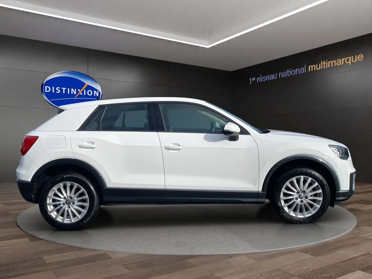 Profil côté gauche d'un Audi Q2 blanc 2019 avec jantes alliage et détails noirs sur les bas de caisse.