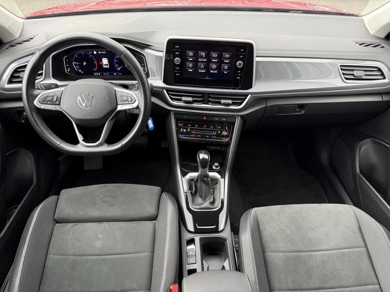 Vue intérieure du tableau de bord et volant cuir multifonction du Volkswagen T-Roc 2023 avec écran tactile central et sièges gris.