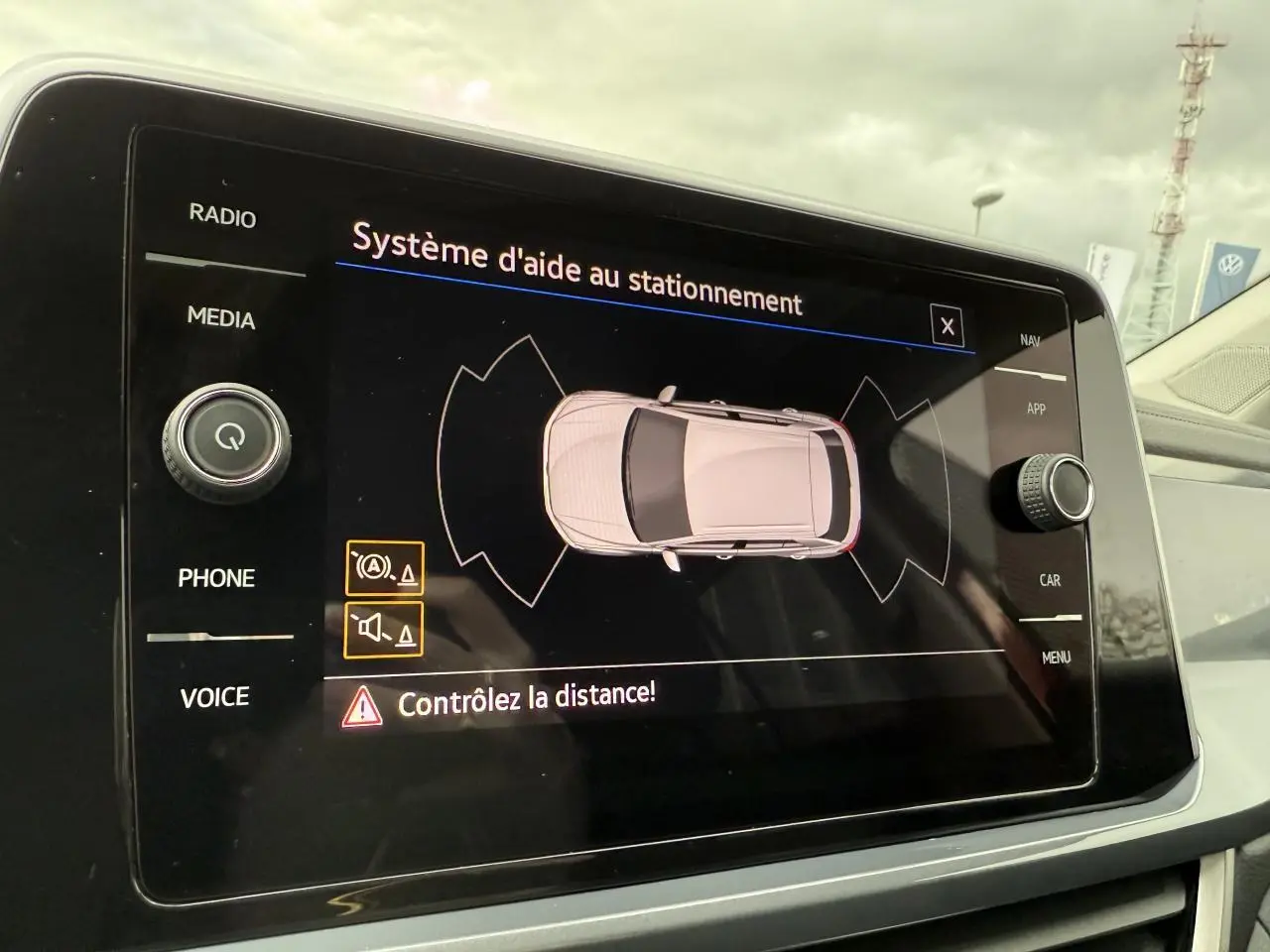 Écran tactile du système d'aide au stationnement du Volkswagen T-Roc rouge Kings Red, vue intérieure centrale.
