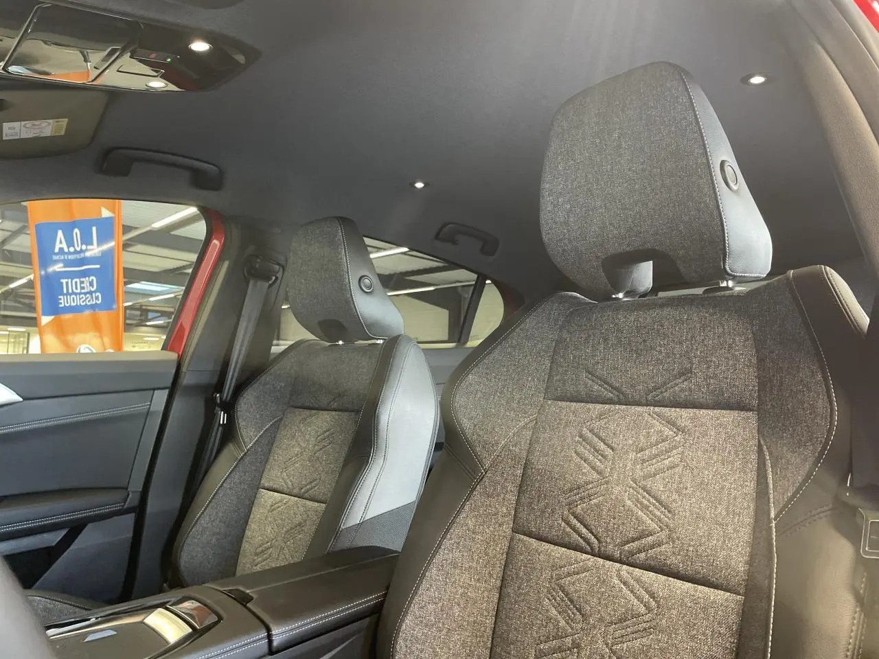 Vue intérieure côté droit des sièges avant en textile gris avec surpiqûres et sellerie mixte du Renault Rafale rouge 2025.