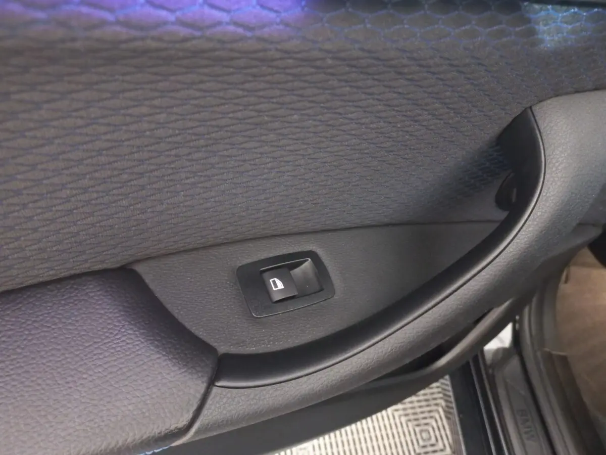 Bouton de commande de lève-vitre sur la porte intérieure côté droit d’un BMW X1 noir 2022 xDrive20d M Sport.