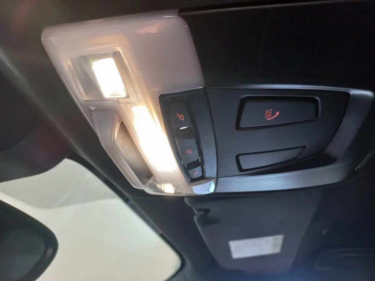 Vue intérieure en plongée du plafonnier noir et blanc avec boutons d’éclairage et alerte SOS du BMW X1 xDrive20d M Sport 2022.