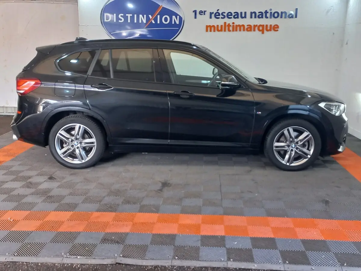 BMW X1 xDrive20d M Sport noir vue de profil côté gauche, avec jantes alliage et vitres teintées.