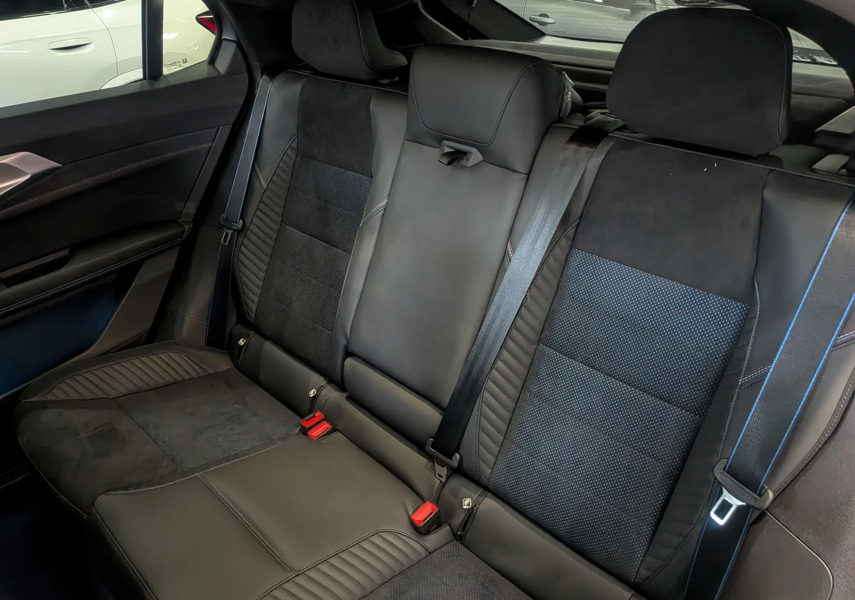 Vue intérieure des sièges arrière en cuir noir et alcantara avec surpiqûres bleues du Renault Rafale hybride rechargeable 2025.