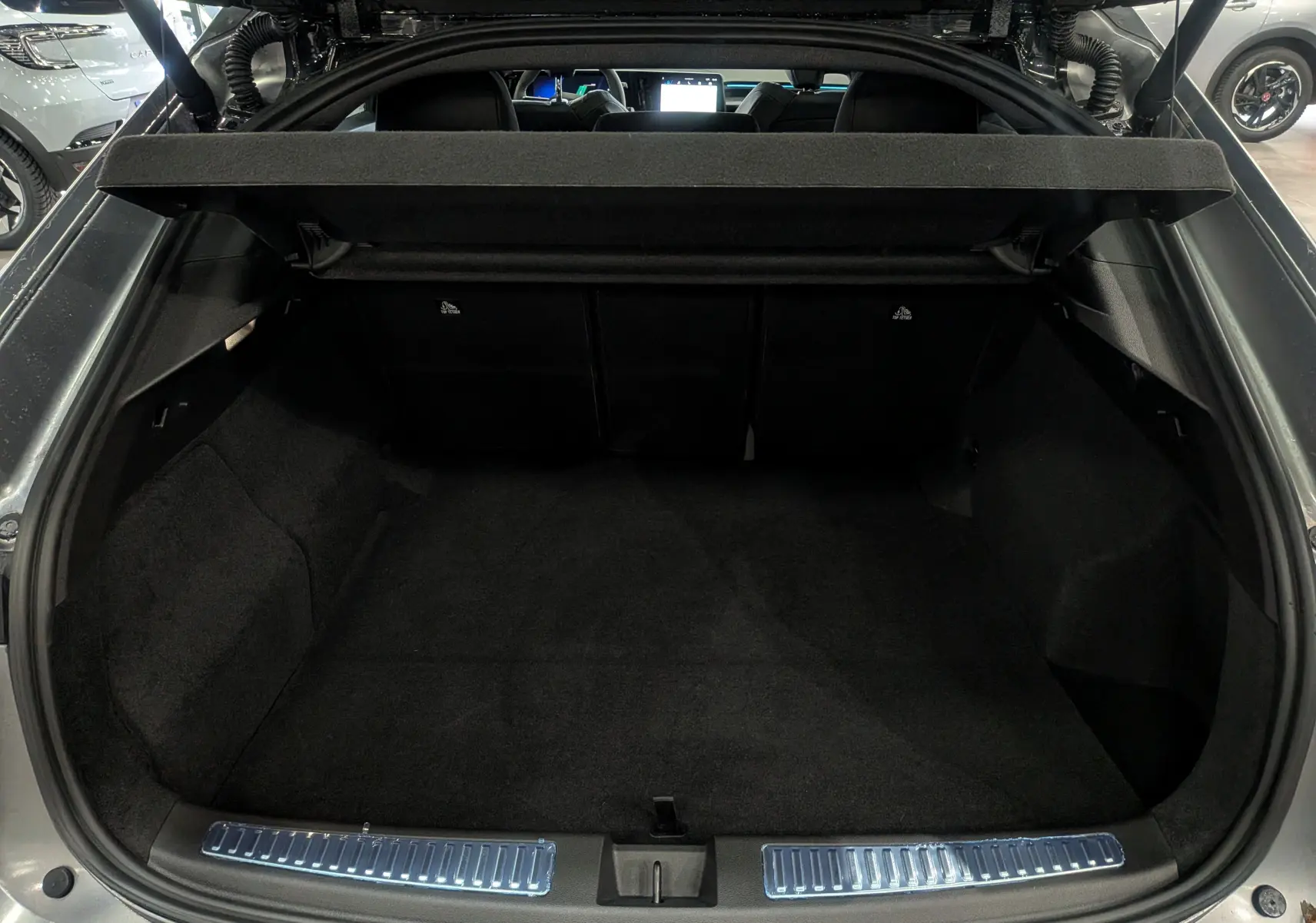 Coffre ouvert vu de l'arrière d'une Renault Rafale gris schiste satin, montrant l'espace de chargement et la tablette arrière.