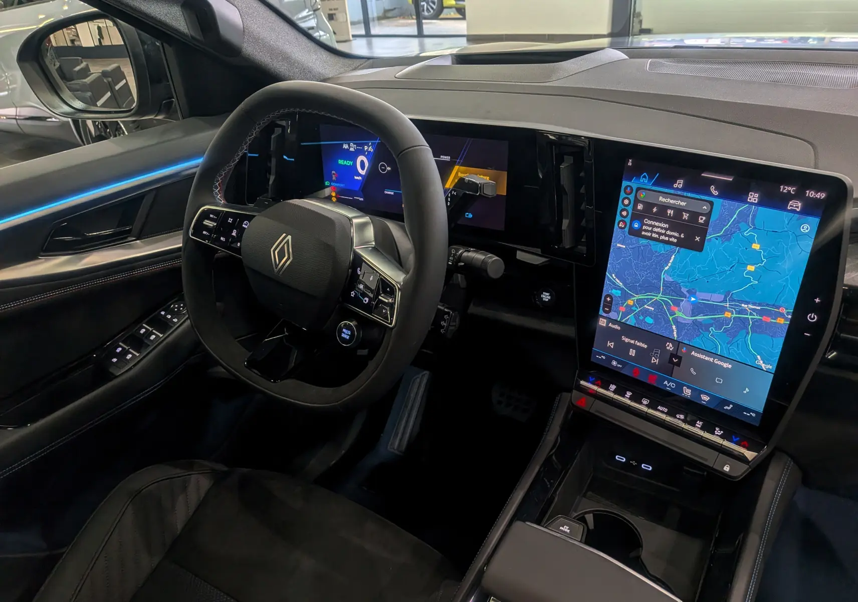 Vue intérieure côté conducteur du Renault Rafale 2025, volant multifonction et grand écran tactile central avec navigation.