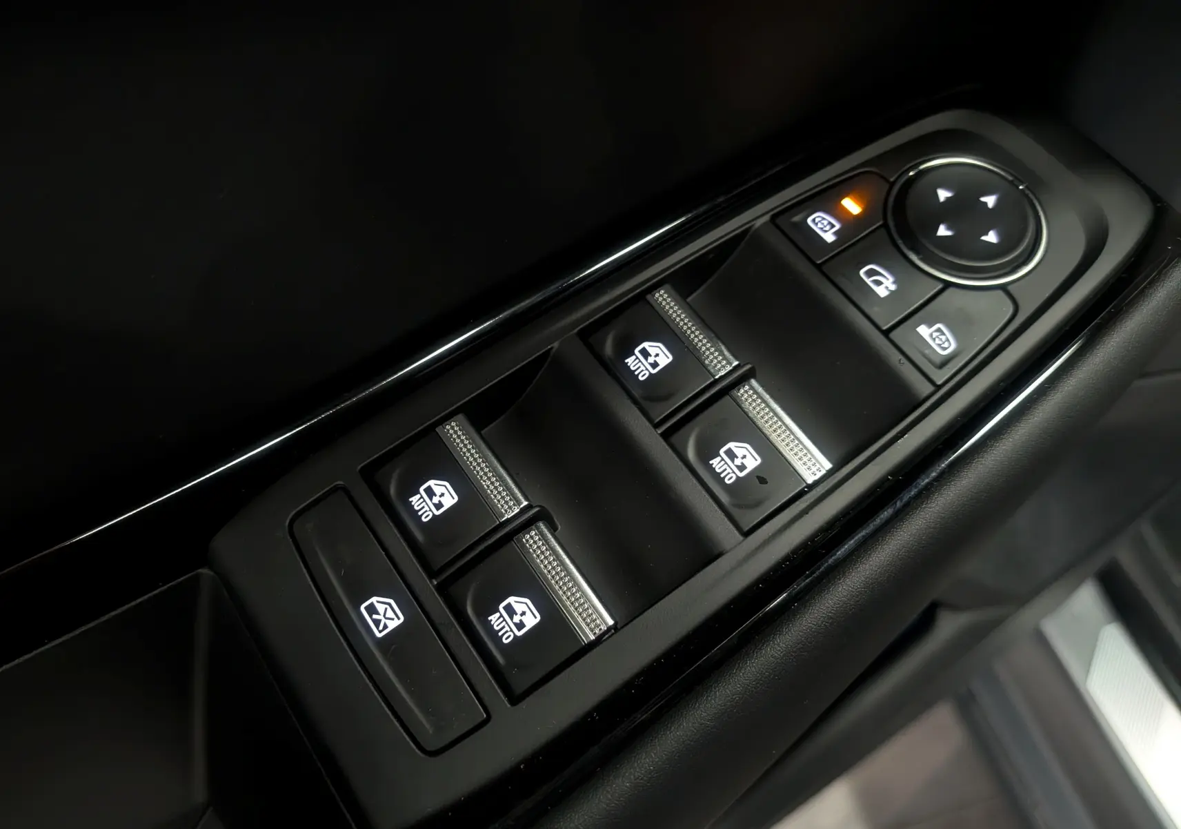 Gros plan sur les commandes des vitres électriques et rétroviseurs côté gauche intérieur d’une Renault Rafale gris Schiste Satin.