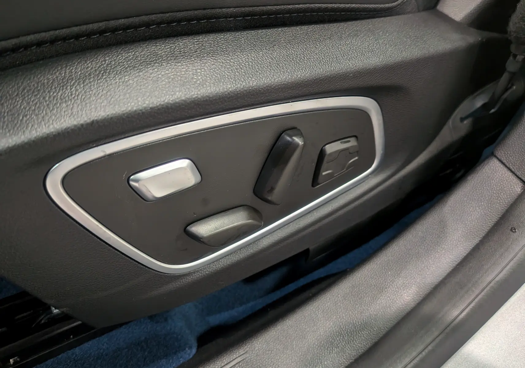 Gros plan sur les commandes de réglage électrique du siège côté gauche d'une Renault Rafale gris schiste satin.