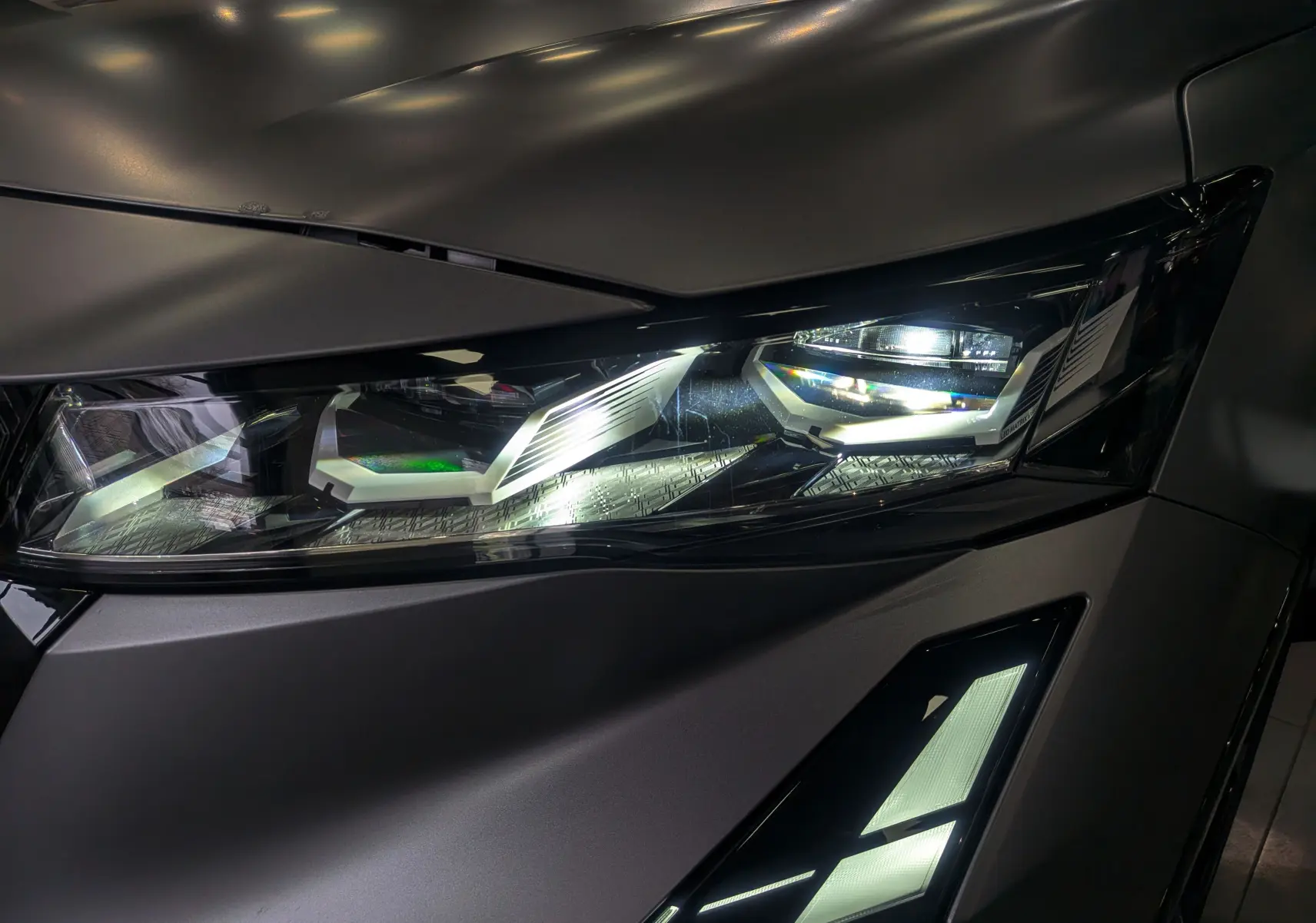 Gros plan sur le phare avant droit du Renault Rafale gris Schiste Satin, mettant en valeur son design LED moderne.