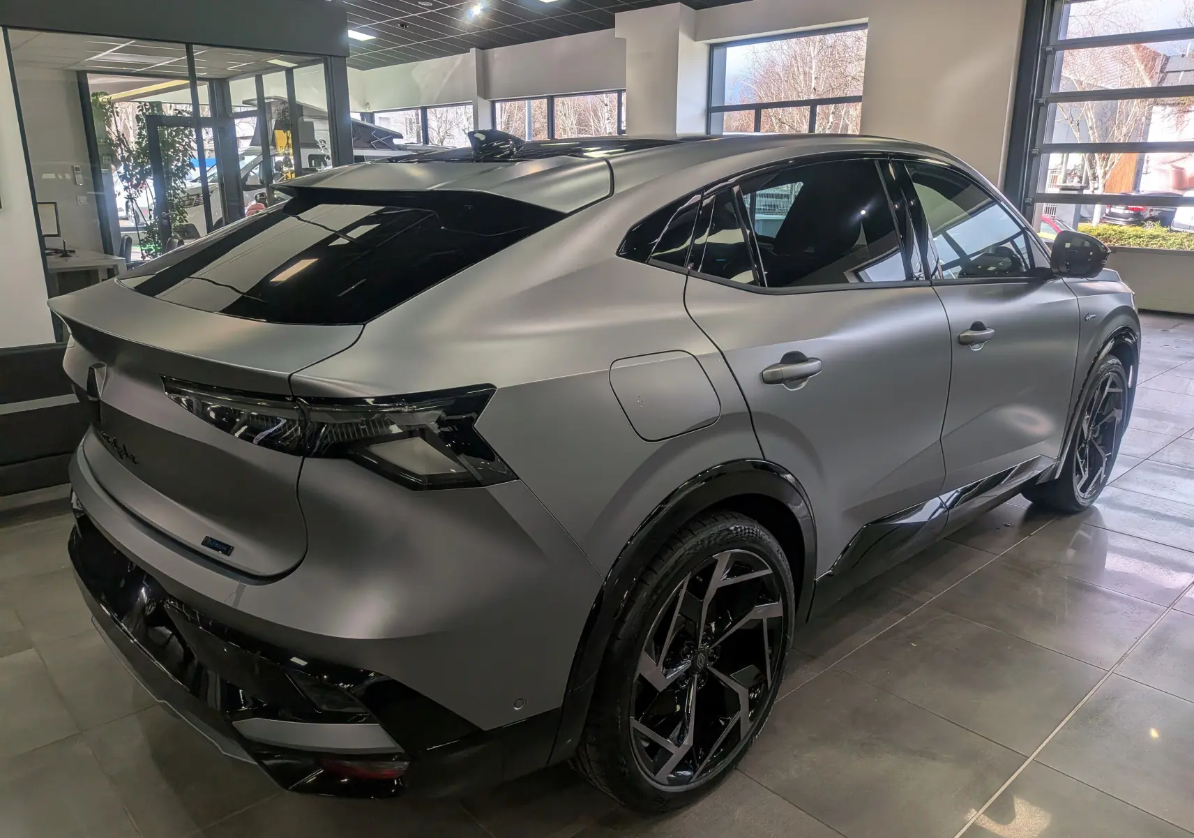 Vue 3/4 arrière droite du Renault Rafale gris schiste satin, soulignant ses lignes fluides et ses jantes noires distinctives.