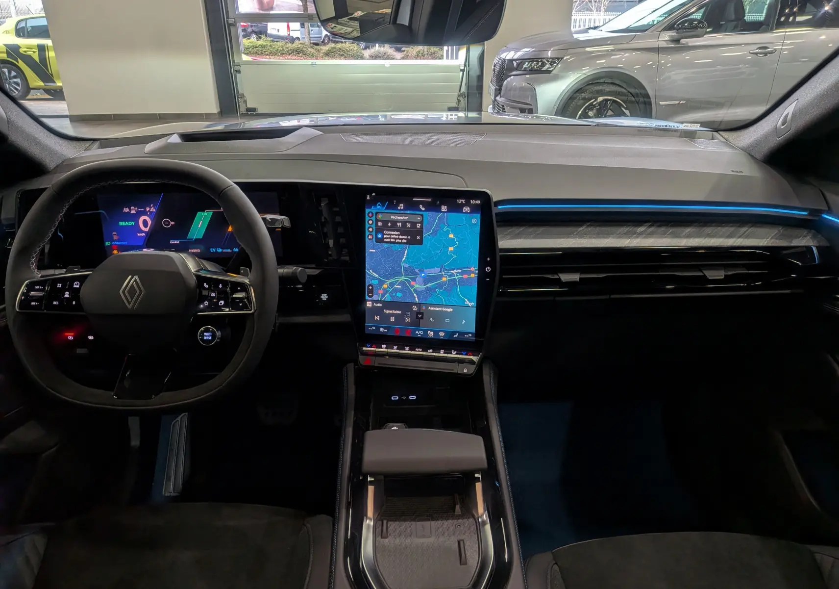 Vue intérieure avant du Renault Rafale gris Schiste Satin, mettant en valeur le tableau de bord numérique et l'écran central tactile vertical.