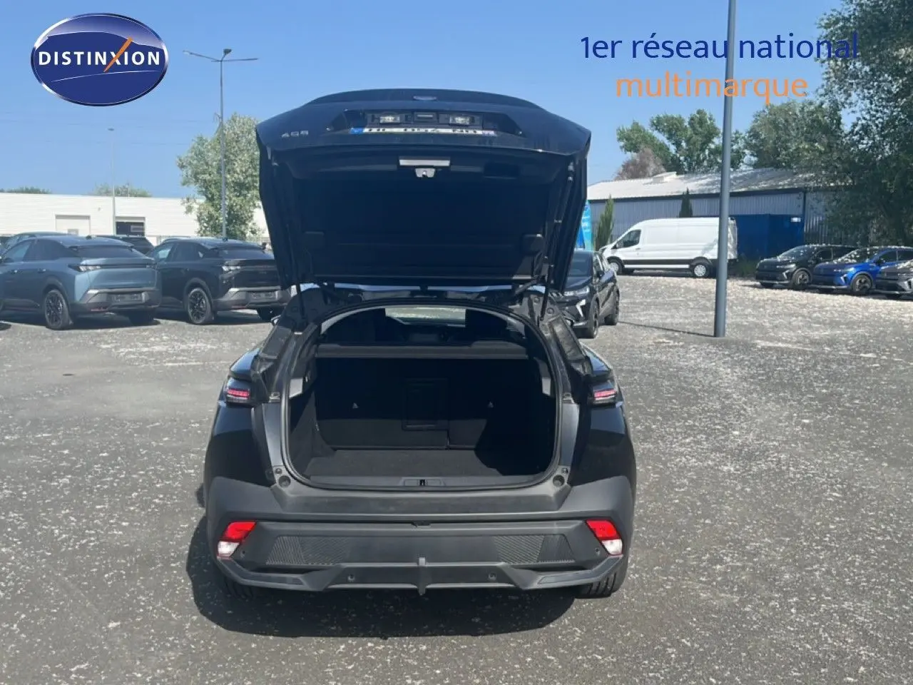Vue arrière d'une Peugeot 408 noire métal 2025 avec coffre ouvert, soulignant son espace de chargement.