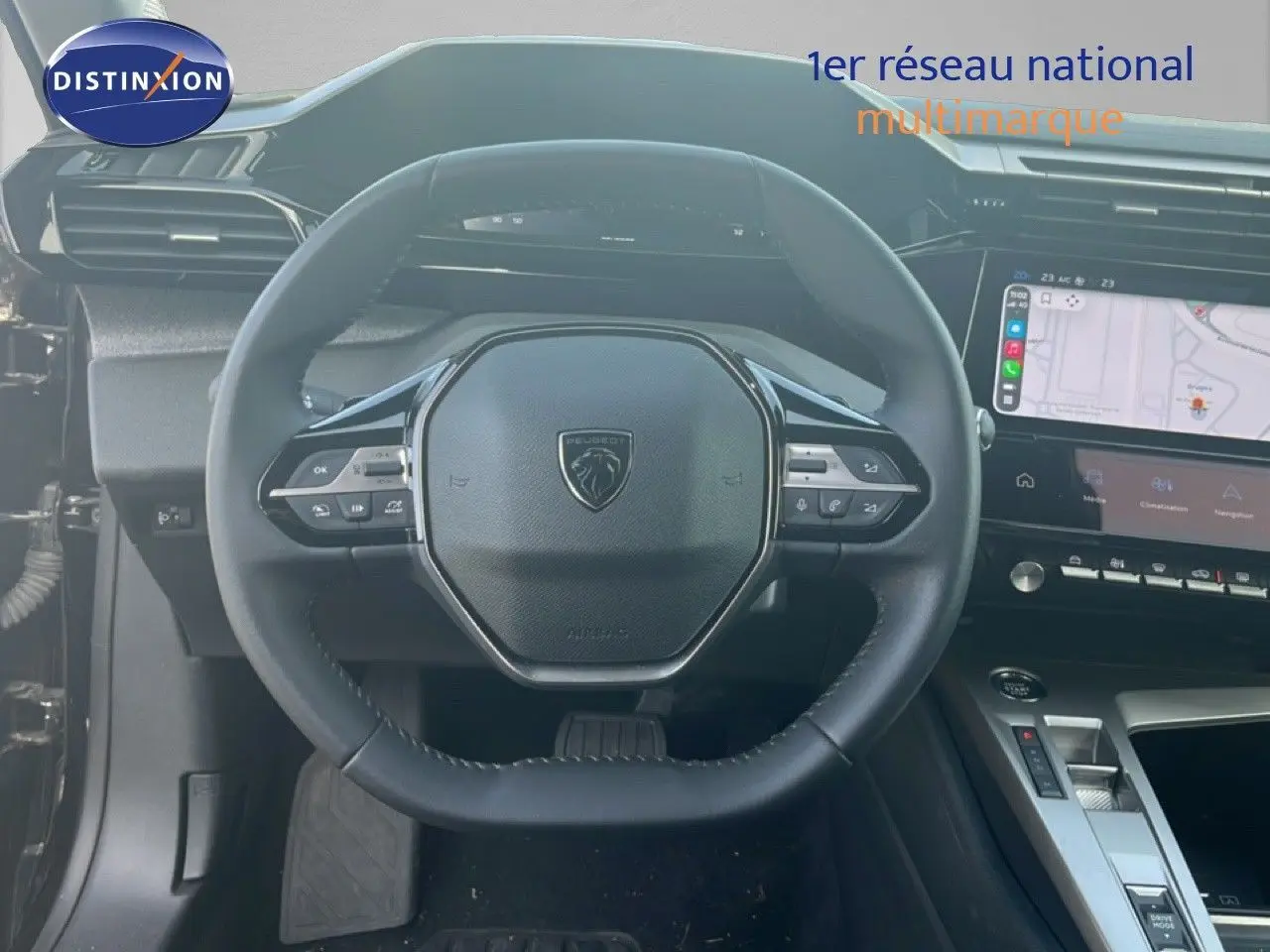 Vue intérieure centrée sur le volant cuir noir de la Peugeot 408 1.2 Hybrid 2025 avec tableau de bord numérique et écran tactile.