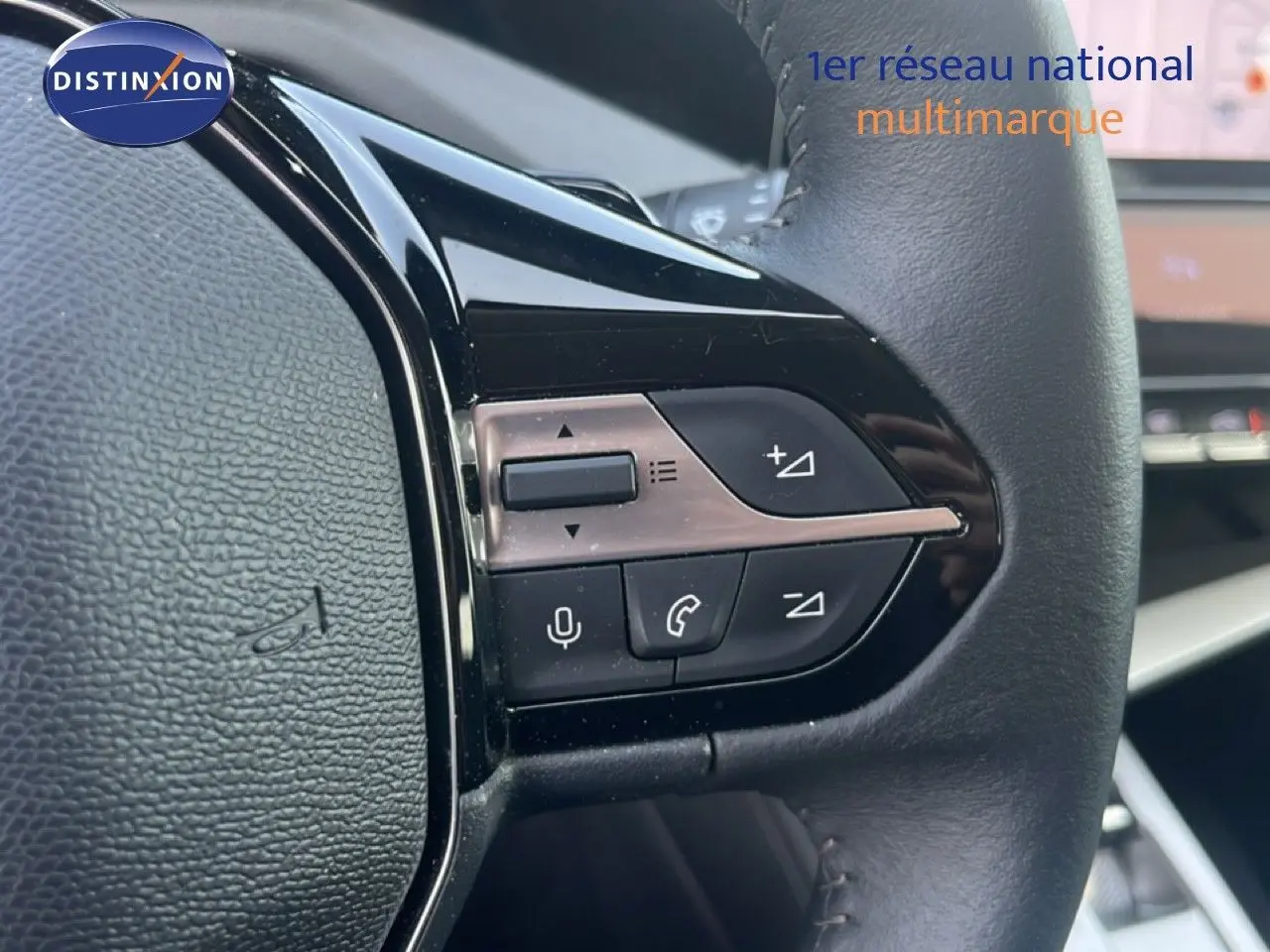 Gros plan sur les commandes au volant côté gauche d’un Peugeot 408 noir métal, avec boutons de volume et téléphone.