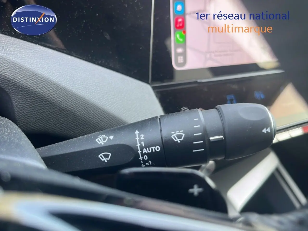 Gros plan sur la commande d’essuie-glace avec affichage tactile en arrière-plan dans un Peugeot 408 noir métal 2025.