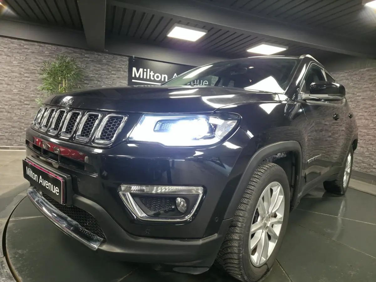 Jeep Compass noir en 3/4 avant droit avec phares LED allumés et jantes alliage 18 pouces visibles.