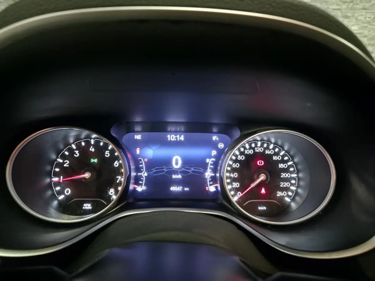 Vue rapprochée du tableau de bord numérique du Jeep Compass 2021, affichant vitesse et compte-tours.