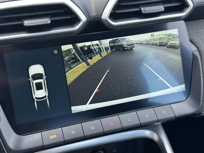 Vue de l'écran tactile intérieur montrant la caméra de recul et l'affichage 360° du MG ZS blanc hybride.