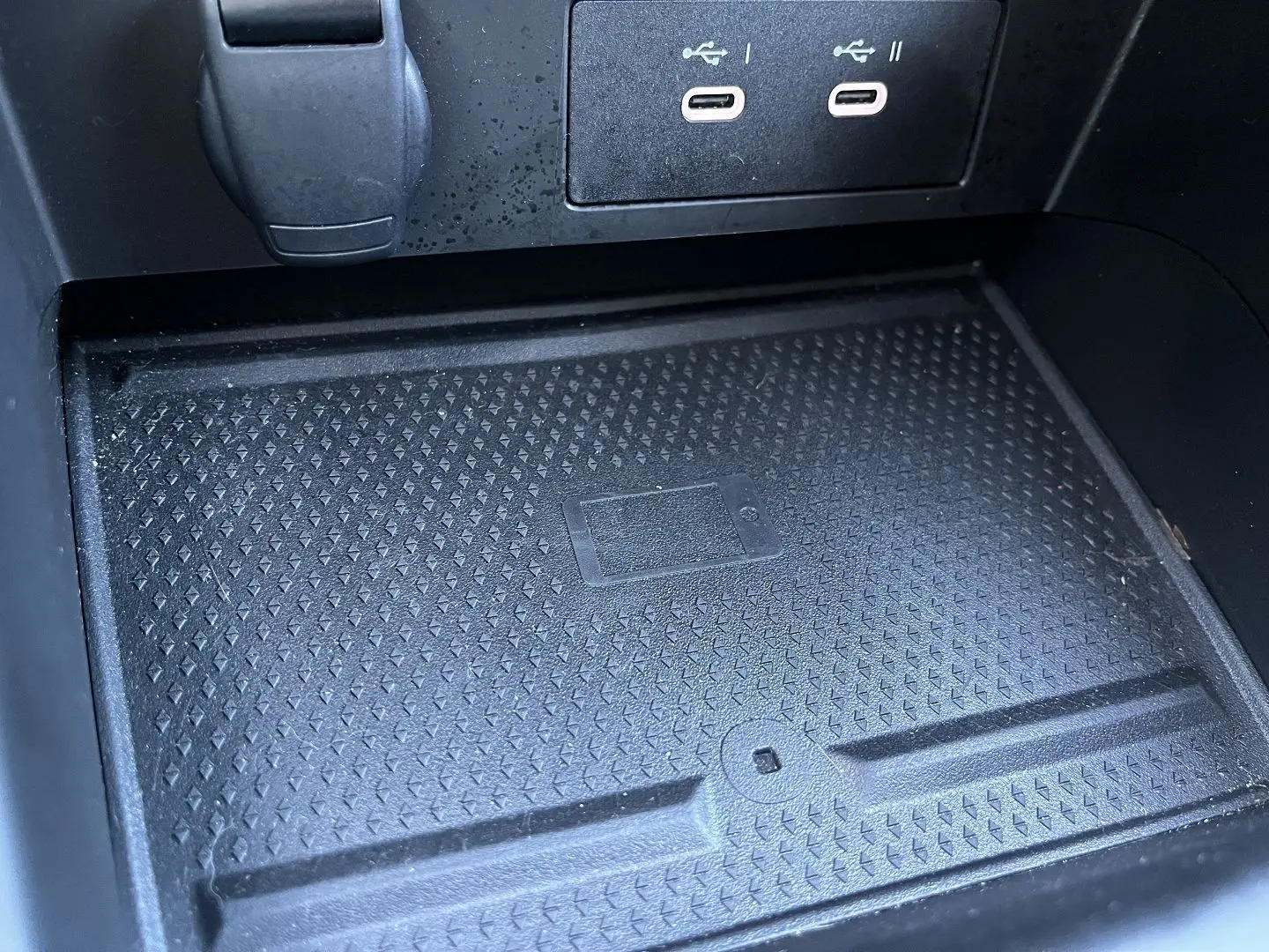 Gros plan sur la zone de recharge sans fil et ports USB du Renault Captur 2025, finition gris rafale toit noir.
