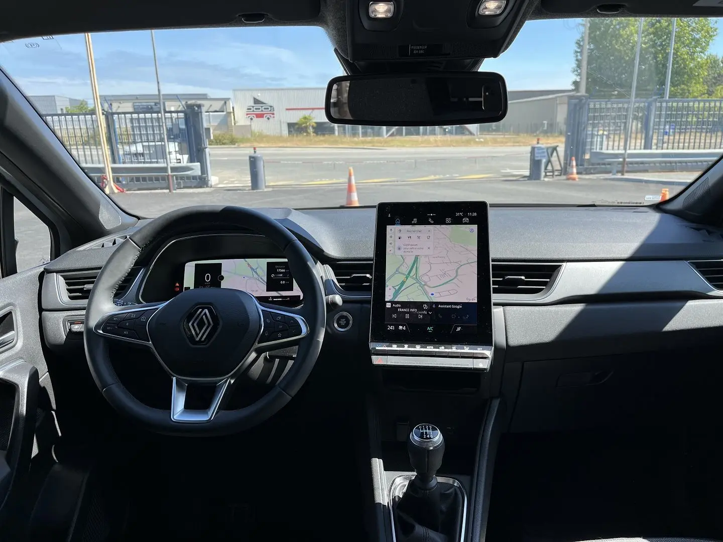 Vue intérieure frontale du tableau de bord du Renault Captur 2025 gris rafale, avec écran tactile vertical et boîte manuelle.