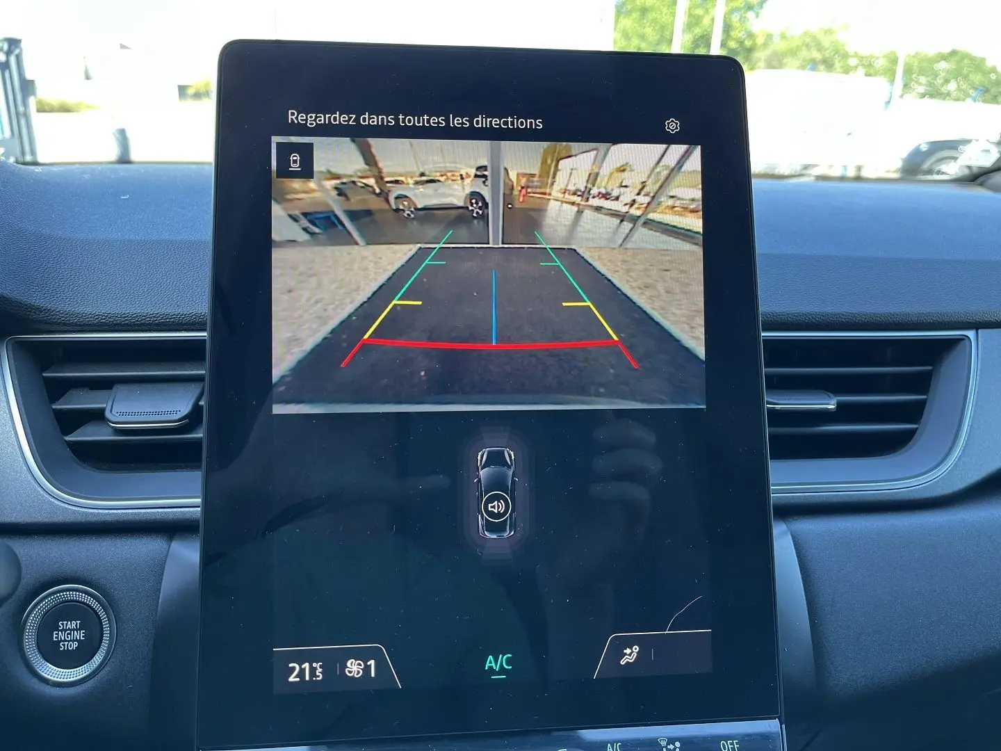 Vue intérieure du tableau de bord du Renault Captur 2025, écran central affichant la caméra de recul avec lignes de guidage colorées.