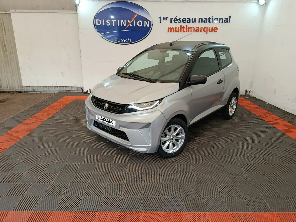 Aixam Ambition 0.5 City Crossline Pack gris foncé vue 3/4 avant droit en intérieur showroom.