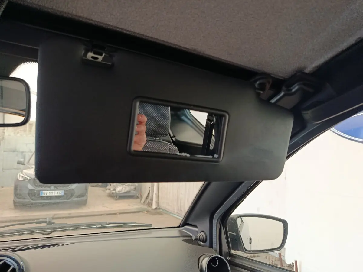 Détail intérieur du pare-soleil avec miroir ouvert côté conducteur d'une Aixam Ambition gris foncé, vue depuis l'habitacle.