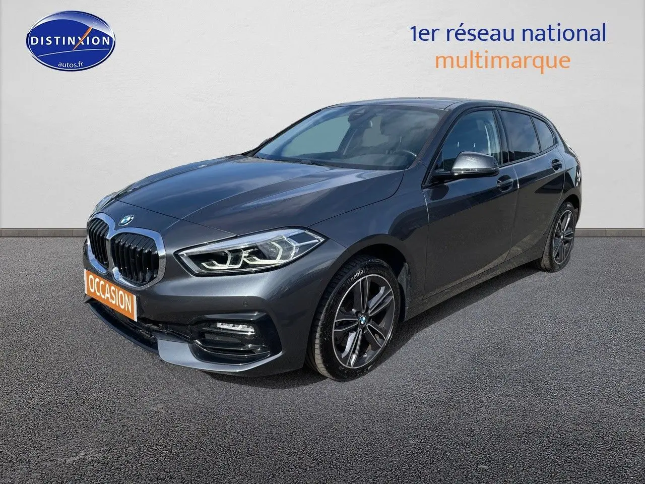 BMW Série 1 gris minéral métal vue 3/4 avant droit avec jantes alliage et calandre double haricot chromée.