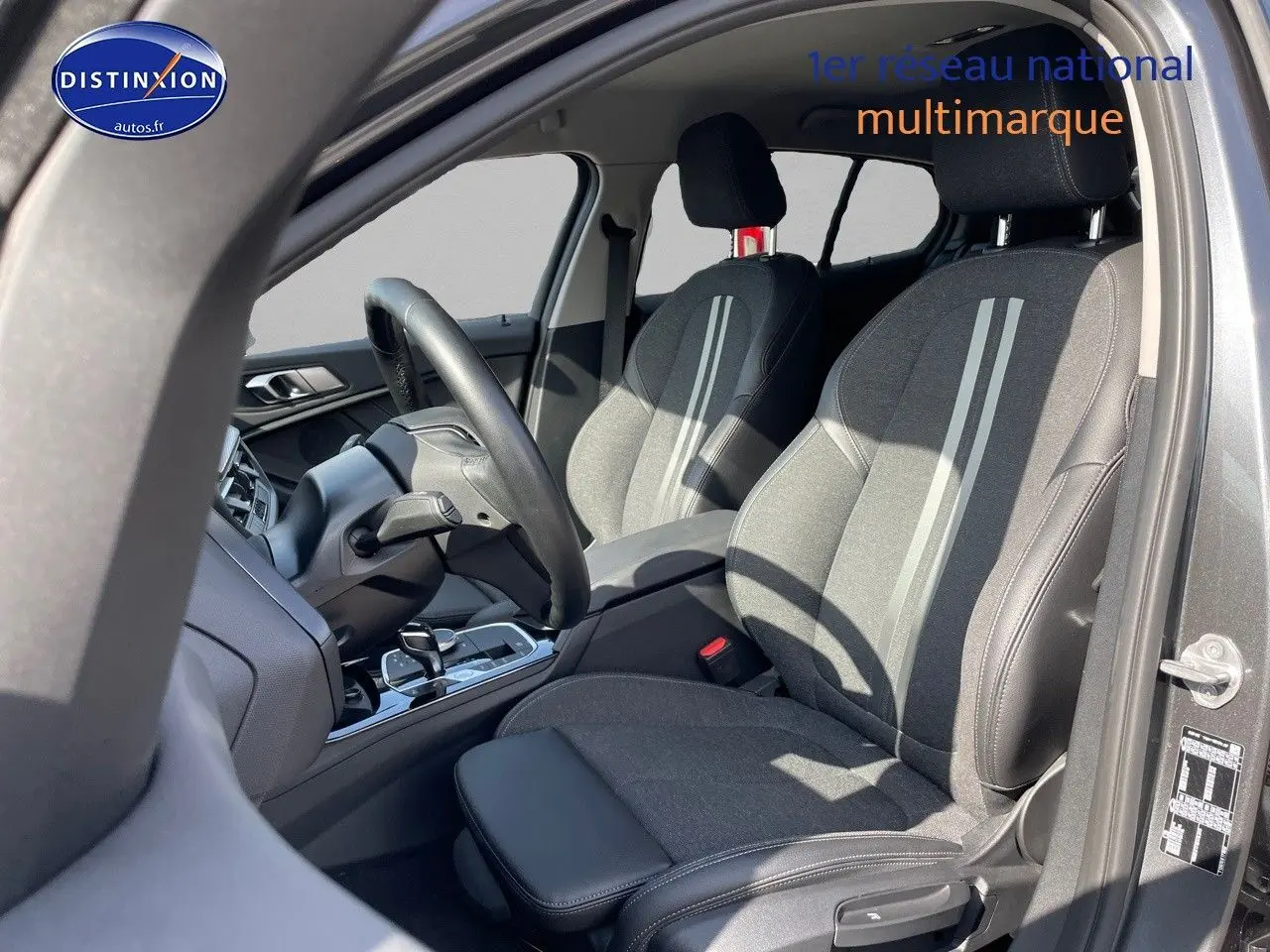 Intérieur avant droit de la BMW Série 1 gris minéral, sièges sport tissu et cuir avec bandes claires centrales.